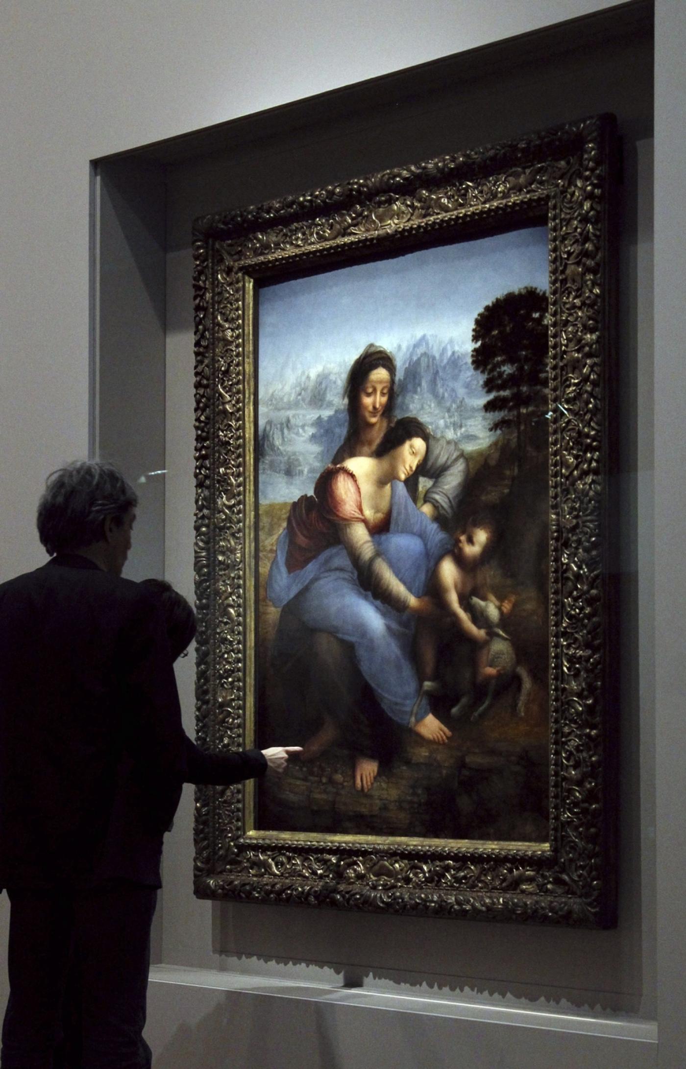 Visiteurs devant La Vierge, l’Enfant Jésus et sainte Anne de Léonard de Vinci, le 23 mars 2012 au Musée du Louvre, à l'occasion de l'exposition "La Sainte Anne : L'ultime chef-d'œuvre de Léonard de Vinci", dévoilant le tableau après sa récente restauration.