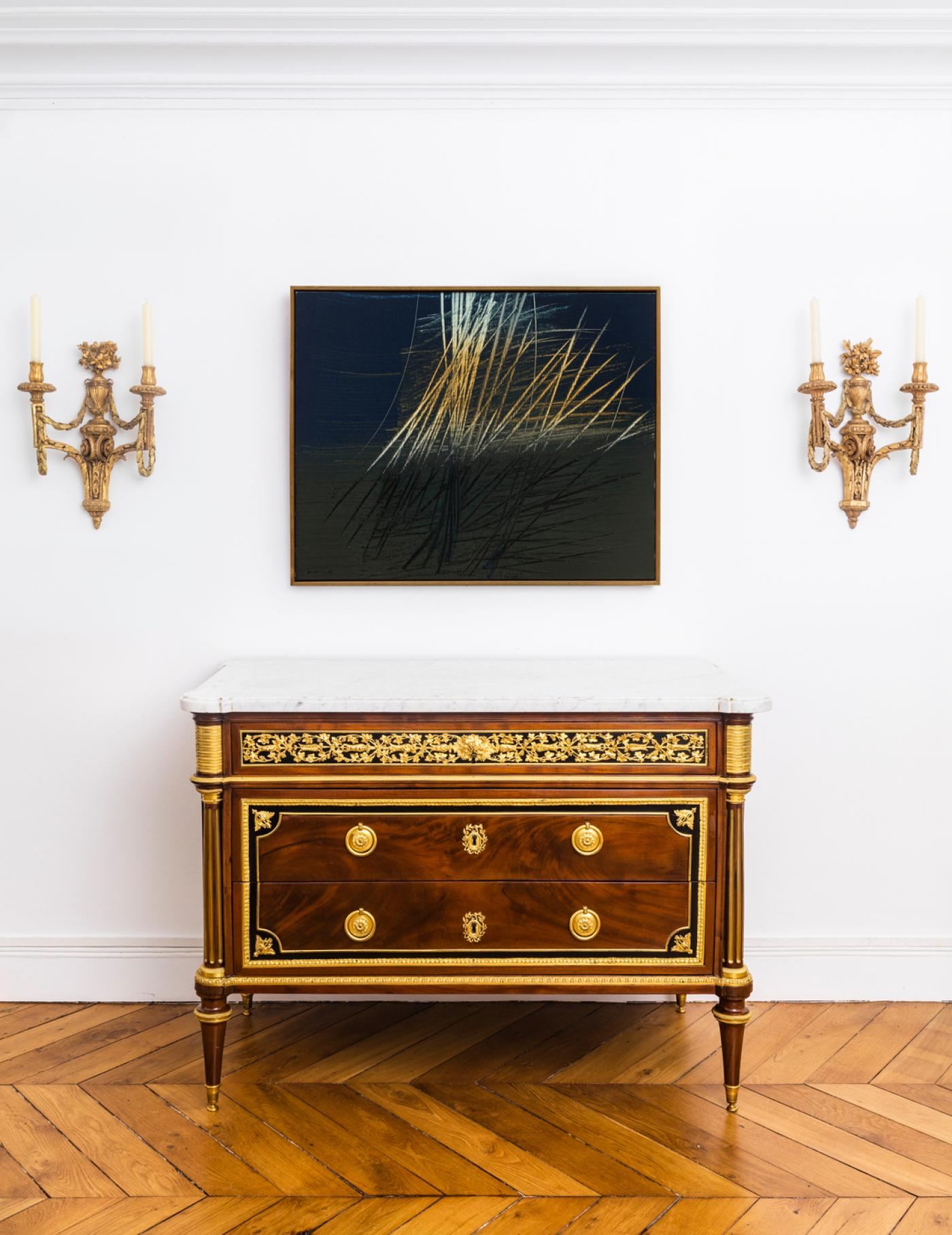 Hans Hartung, "T 1963-U 15", acrylique sur toile, 1963, 65 x 81cm.
Collection particulière.
Commode en placage d’ébène et acajou, ornée de bronzes ciselés,
ajourés et dorés, dessus en marbre blanc veiné, dernier quart du 18e
siècle, époque Louis XVI, estampille de Jean-Jacques Pafrat, 84 x 117 x 62 cm.
