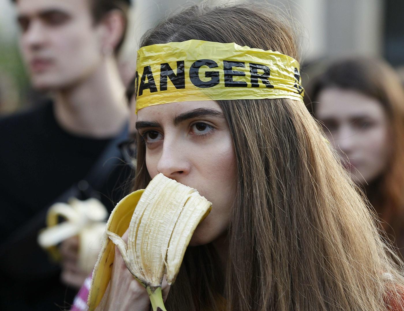 Des personnes manifestant avec des bananes devant le Musée national de Varsovie, en Pologne, le lundi 29 avril 2019, pour protester contre la censure de l'œuvre de Natalia LL, Consumer Art.