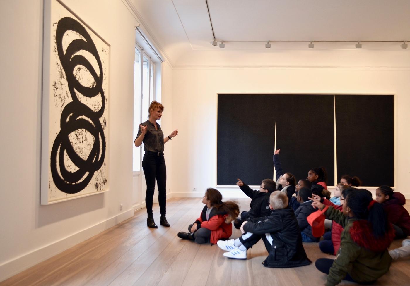 Nathalie Berghege présentant une œuvre de l'exposition « Richard Serra » à des écoliers, galerie Lelong &amp; Co, mars 2018.