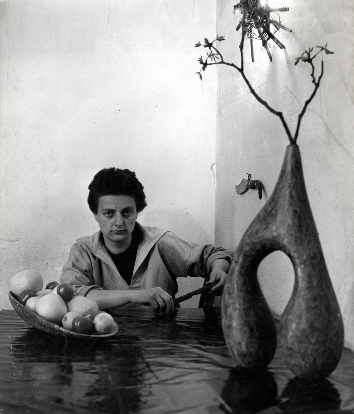 Agnès Varda, "Valentine Schlegel avec un couteau de sa collection - vase et plat, rue Daguerre, Paris", 1955, tirage argentique posthume noir et blanc sur papier Warmtone à partir du négatif 6x6, 60,5 x 40,5 x 3,5 cm encadré. Édition 1/10.