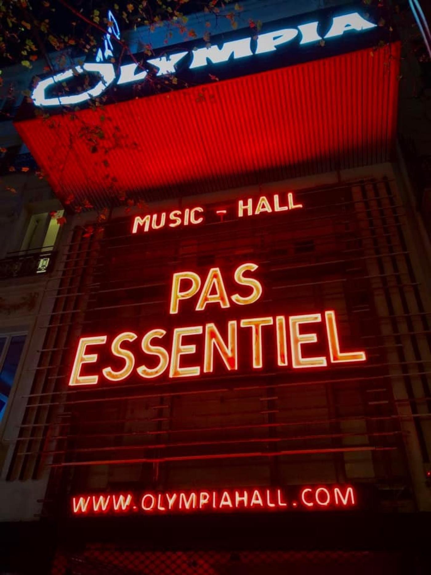 "PAS ESSENTIEL" en lettres lumineuses sur le fronton de l'Olympia.