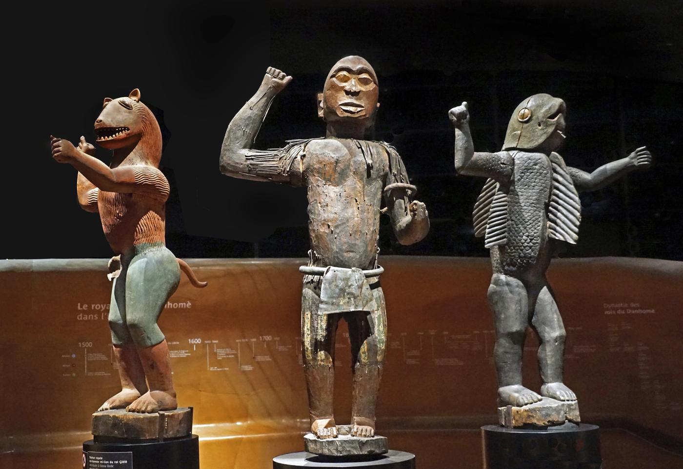 Les statues du palais royal d'Abomey au musée du quai Branly, Paris. De gauche à droite : statue royale anthropo-zoomorphe à tête de lion évoquant le règne du roi Glélé ; statue anthropomorphe représentant probablement le roi Ghézo ; statue royale anthropo-zoomorphe à tête et torse de requin représentant le roi Béhanzin, dernier roi du Dahomey.


