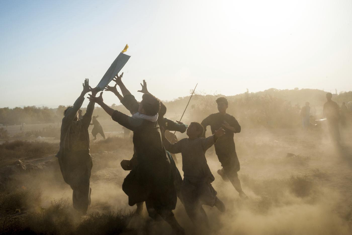 Des adolescents essaient d'attraper un cerf-volant tombé lors d'une bataille de goudi parân à Hérat. Photographie de Morteza Herati, prise avant le retour au pouvoir des Talibans.