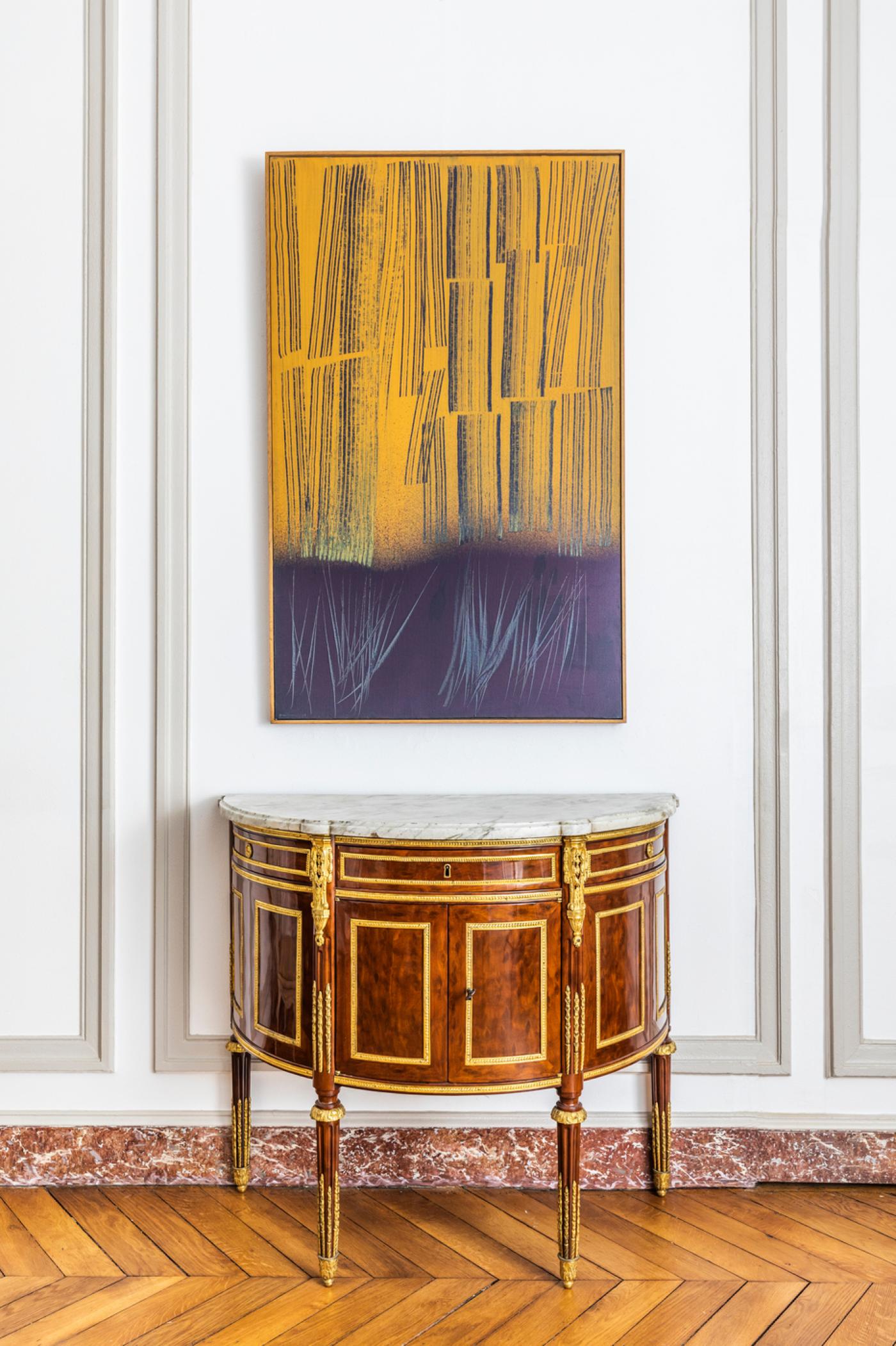 En haut : Hans Hartung, T1964-H37, 1964, acrylique sur toile, 130 x 81 cm.
En dessous : commode en placage d’acajou moucheté estampillé René Dubois, époque Louis XVI.
